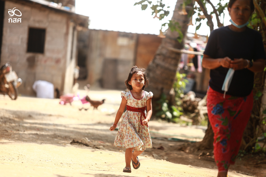 เด็กหญิงปฐมวัยใส่ชุด dress เดินอยู่ในชุมชนที่ห่างไกลตัวเมือง